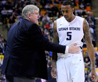 Utah State coach Stew Morrill, left, talks with Jarred Shaw, who walks off the court during an NCAA college basketball game against UNLV, Saturday, Feb. 15, 2014, in Logan, Utah.
